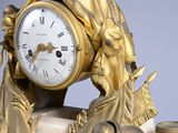 a gold clock sitting on top of a marble table