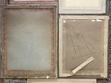 a pile of old picture frames on the floor