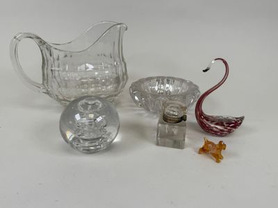 un pichet en verre, un saladier en verre et une figurine de cygne en verre posés sur une surface blanche