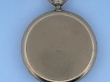 a small silver pocket watch on a blue surface