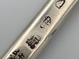 a silver spoon with writing on it sitting on a table