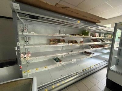 de nombreuses étagères vides dans un magasin où sont disposés des produits alimentaires
