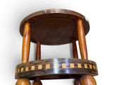 a small wooden stool with three wooden balls on it