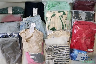 de nombreux types de vêtements différents, rangés dans des sacs posés sur la table