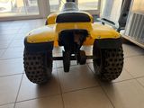 a yellow four wheeler with a black seat in a room