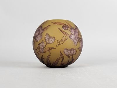 yellow and brown egg with birds on it sitting on a white surface