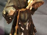 figurine of a monk holding a baby and a book