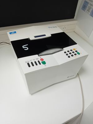 un boîtier blanc sur lequel est posée une télécommande