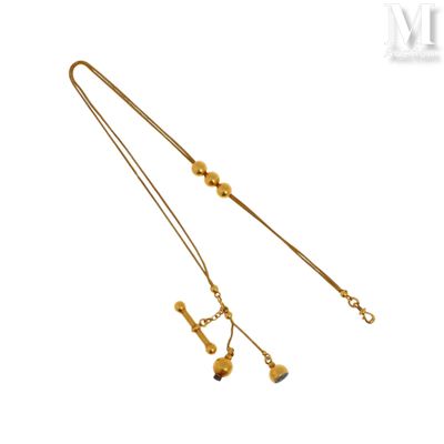 un gros plan d'un collier en or orné de clochettes sur fond blanc