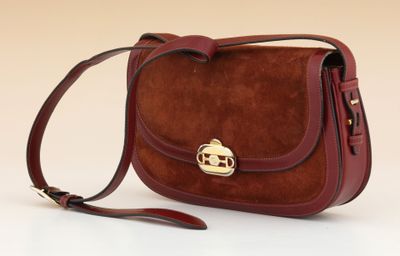 brown sued cross body bag with a gold buckle