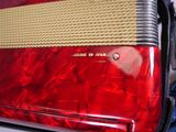 a close up of a red accordion with a yellow band
