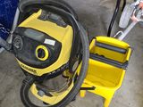 a yellow vacuum and a blue truck in a garage