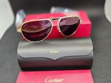 une paire de lunettes de soleil posée sur une boîte rouge, à côté d'une paire de lunettes