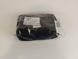a bag of black cloth wrapped in plastic on a white surface