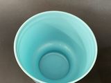 a blue bowl sitting on a table with a black background