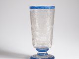 a glass with a blue rim sitting on a white surface