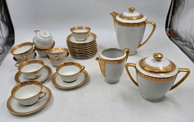un service à thé blanc et or avec tasses et soucoupes