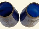two blue vases sitting next to each other on a table