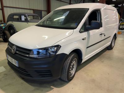 La camionnette blanche est garée dans un garage avec d'autres véhicules.