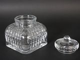 a small glass jar with a lid on a table