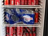 un réfrigérateur rempli de canettes de soda et de canettes de soda