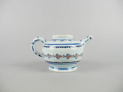 théière en porcelaine bleue et blanche avec une anse et des poignées