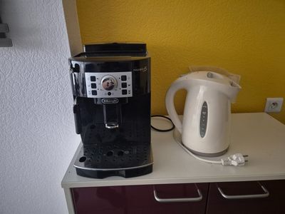 une cafetière et une bouilloire posées sur le plan de travail de la cuisine