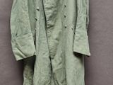 une photo d'un manteau vert accroché à un mur