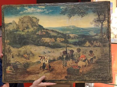 un homme qui tient un tableau devant lui