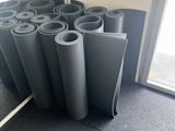 de nombreux rouleaux de tapis de yoga alignés sur le sol