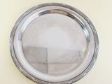 a silver plate on the wall with a mirror above it