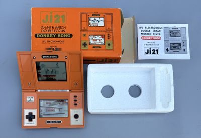 une Game Boy orange posée à côté d'une boîte blanche