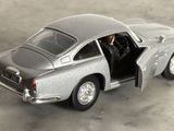 une petite voiture en argent, la portière ouverte, posée par terre