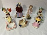 sept figurines d'enfants assis sur une surface blanche