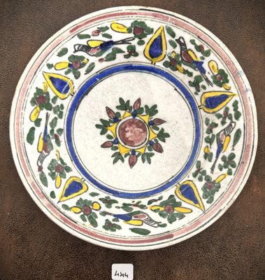 une photo d'une assiette décorée d'un oiseau et de fleurs