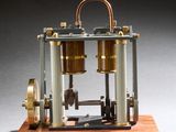 une image représentant une maquette de machine à vapeur posée sur un socle en bois