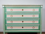 une commode verte et rose avec des poignées dorées