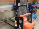 un chariot élévateur dans un entrepôt avec des boîtes sur le sol