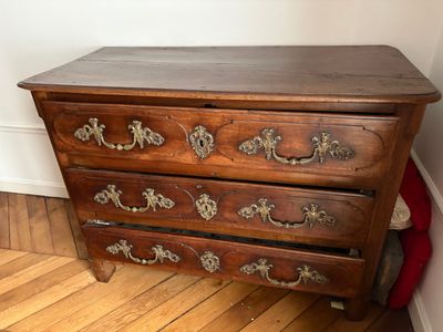 une commode en bois dans une pièce avec du parquet