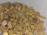 a pile of coins sitting on a table next to a bottle of wine