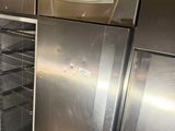 stainless steel refrigerators and freezers in a kitchen with tile flooring