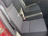 sur les sièges arrière d'une voiture rouge équipée d'une ceinture de sécurité noire