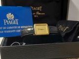 une boîte noire contenant une montre en or et une carte bleue