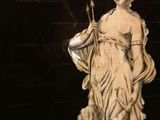 a statue of a woman holding a bird on a pedestal