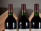 three bottles of wine sit in a wooden crate on a table