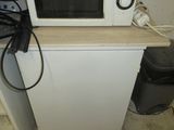 un micro-ondes posé sur un réfrigérateur