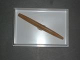 un stylo en bois posé sur un plateau blanc, sur une table