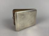 an old silver cigarette case sitting on top of a white table