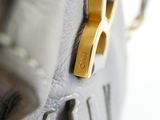 a close up of a purse with a gold handle