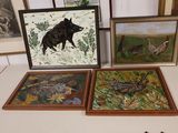 three framed pictures of animals and birds on a table in a room